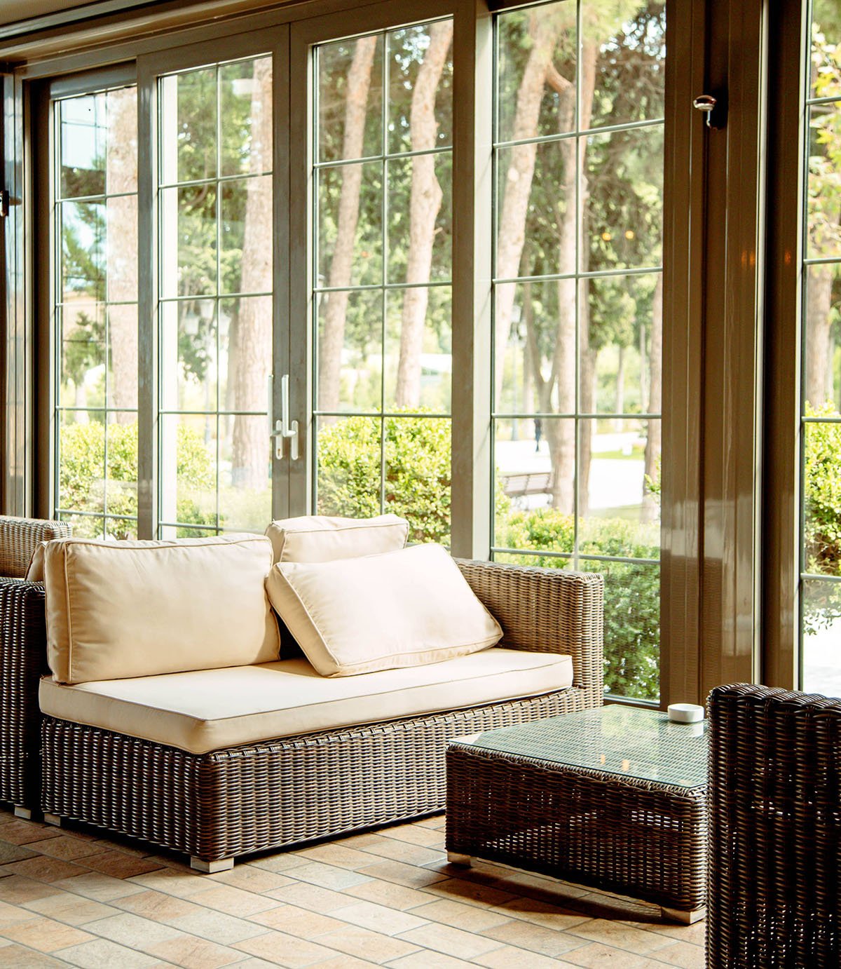 outdoor sofa with beige cushions coffee table front restaurant window scaled e1707485855253